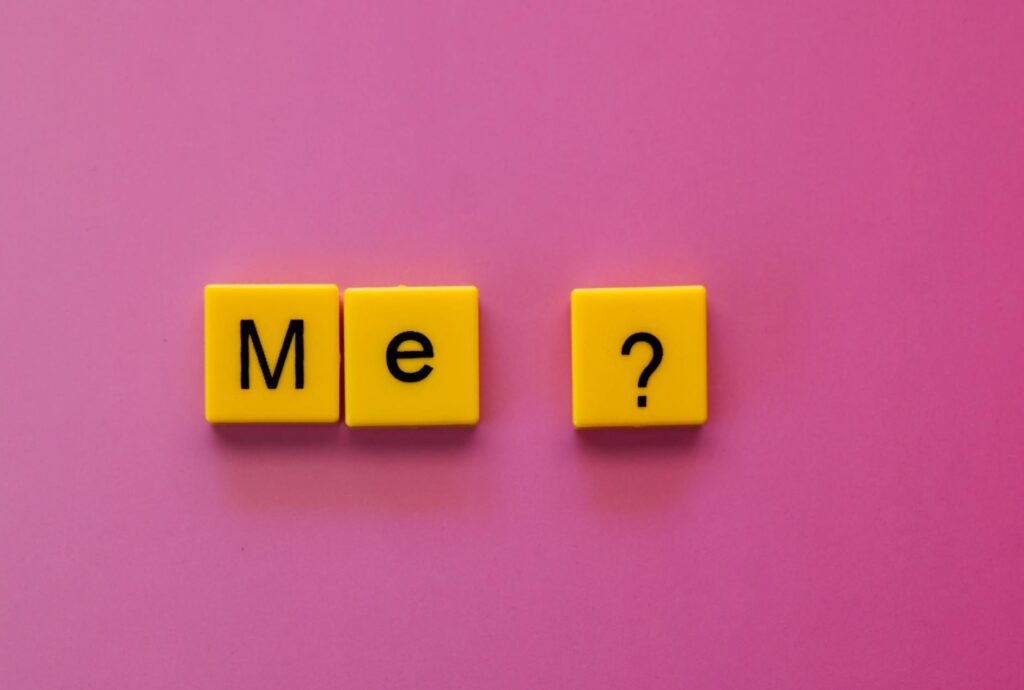 yellow letter tiles spelling me on pink background