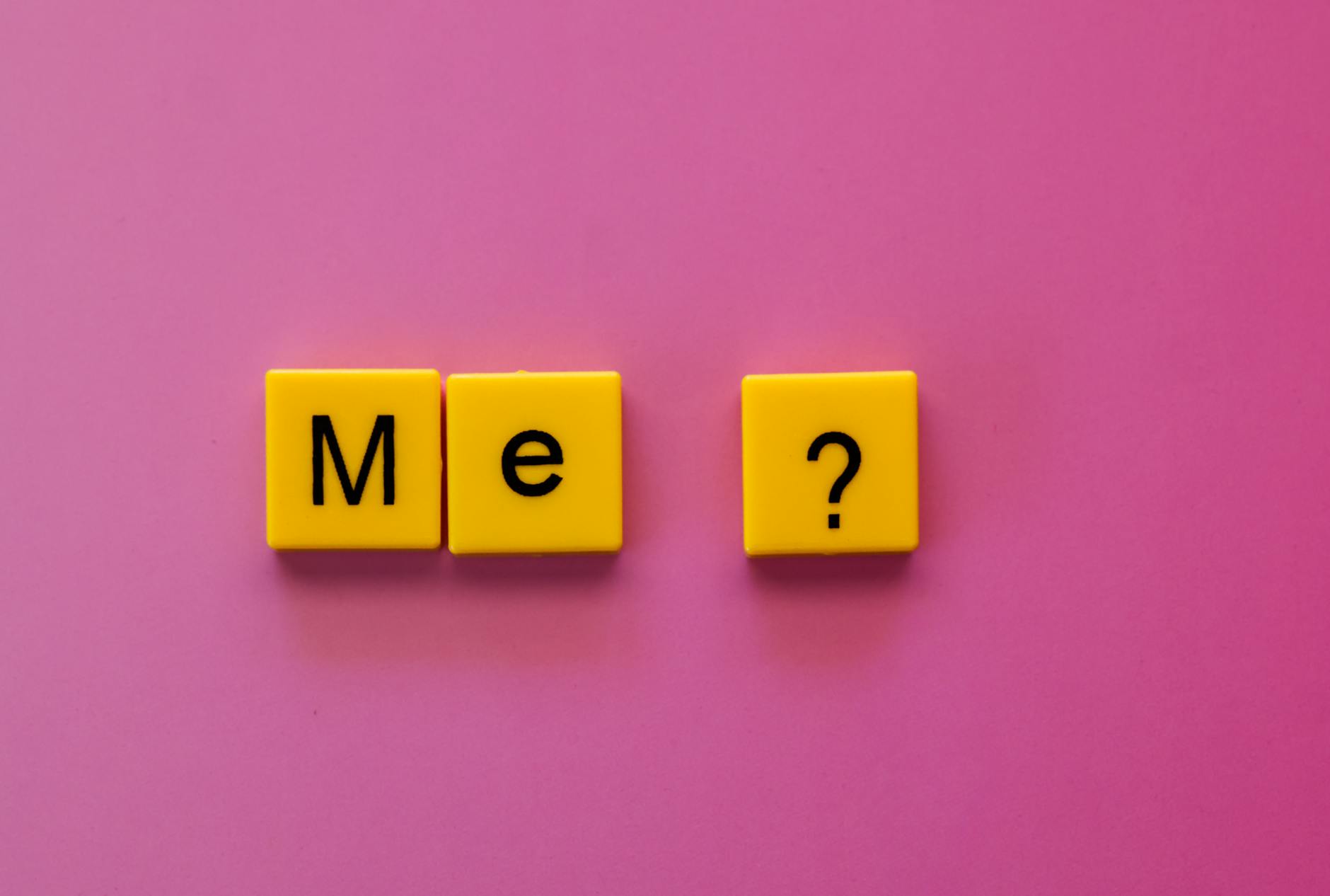 yellow letter tiles spelling me on pink background